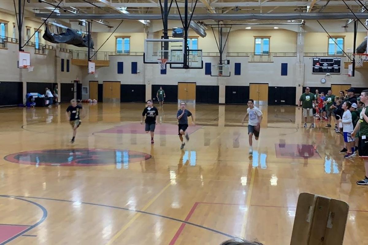 Four boys racing inside a gym
